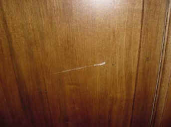Before condition above: Dent and gouge in armoire door before repair.