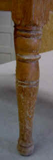 A childs antique commode leg close-up before repairs.