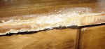 A dog chewed this desk, closeup of metal anchors during repair process.